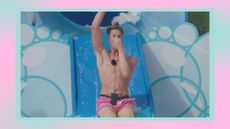 one of the best winter Love Island 2023 memes showing Will Young seen sliding down a slide while holding his nose for one of the Love Island challenges/ in a pink and blue template