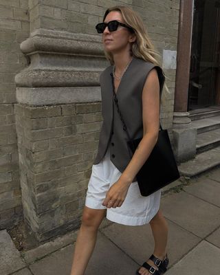 @brittanybathgate wearing white shorts, grey tailored vest and black Birkenstocks