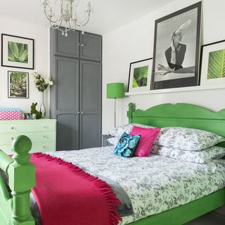 main bedroom with green wooden bed and photoframe on wall