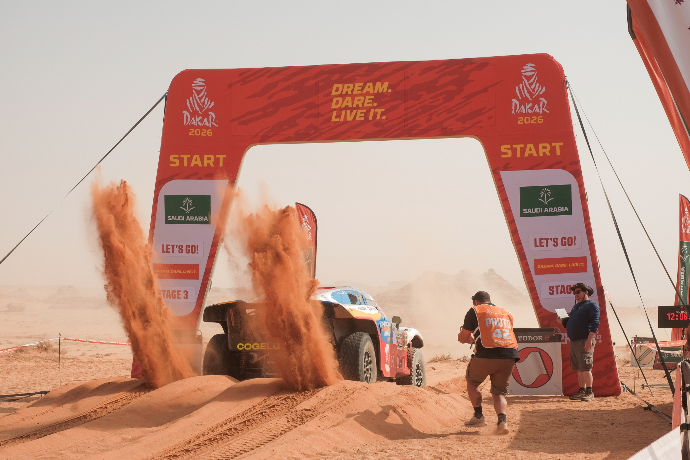 At the start, a car engages its rear wheels, flinging sand up into the air
