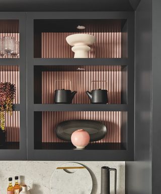 Dark grey open kitchen shelves with light pink painted background