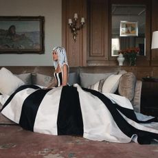 Zendaya sits on a couch wearing a black and white Carolina Herrera gown to reference Venus and Serena Williams in Vogue