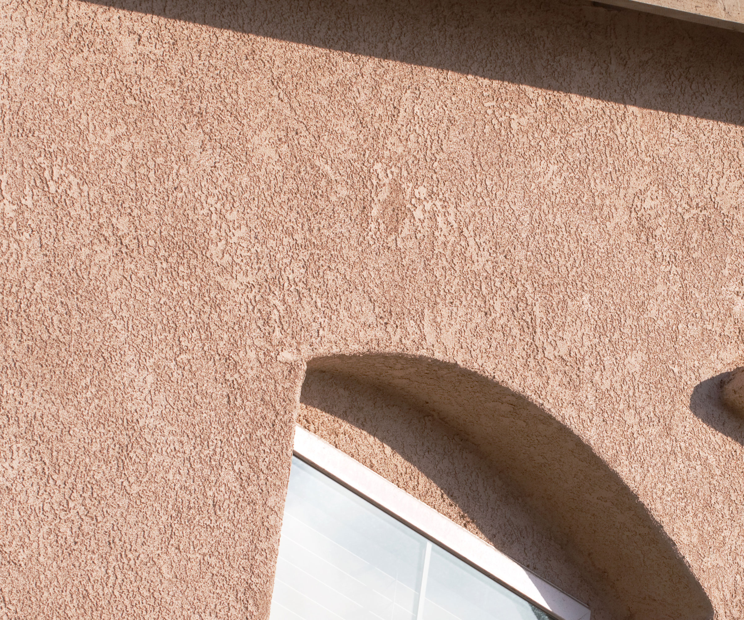 natural brown stucco plastering on exterior walls of house