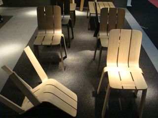 Two columns of wood chairs with no arms.