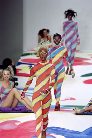 A model displays a bodysuit into spirals of stripes, printing on both sides of monofilament film as part of the Issey Miyake Spring/Summer 1996 ready-to-wear collection