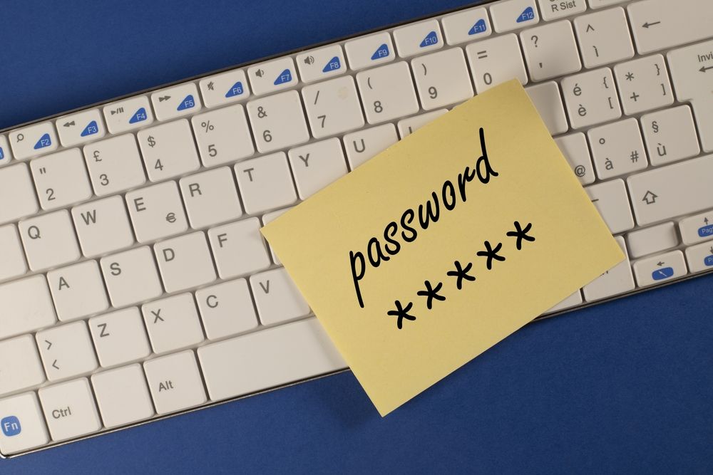 A Post-It note stuck to a keyboard and bearing the words &#039;password&#039; and &#039;*****&#039;.