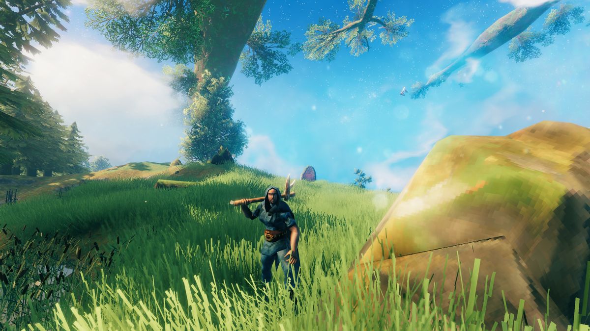 Valheim pickaxe - a Viking is standing next to a large rock, holding a pickaxe. You can see the Yggdrasil tree in the background, crossing the sky