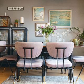Neutral dining room with dining table, pink velvet dining chairs, drinks cabinet and gallery wall