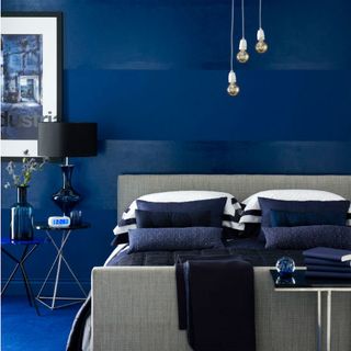 bedroom with blue wall blue floor and bed with pillows