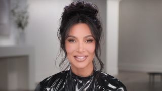 Kim Kardashian smiles as she looks at the camera during an interview in Season 5 of The Kardashians.