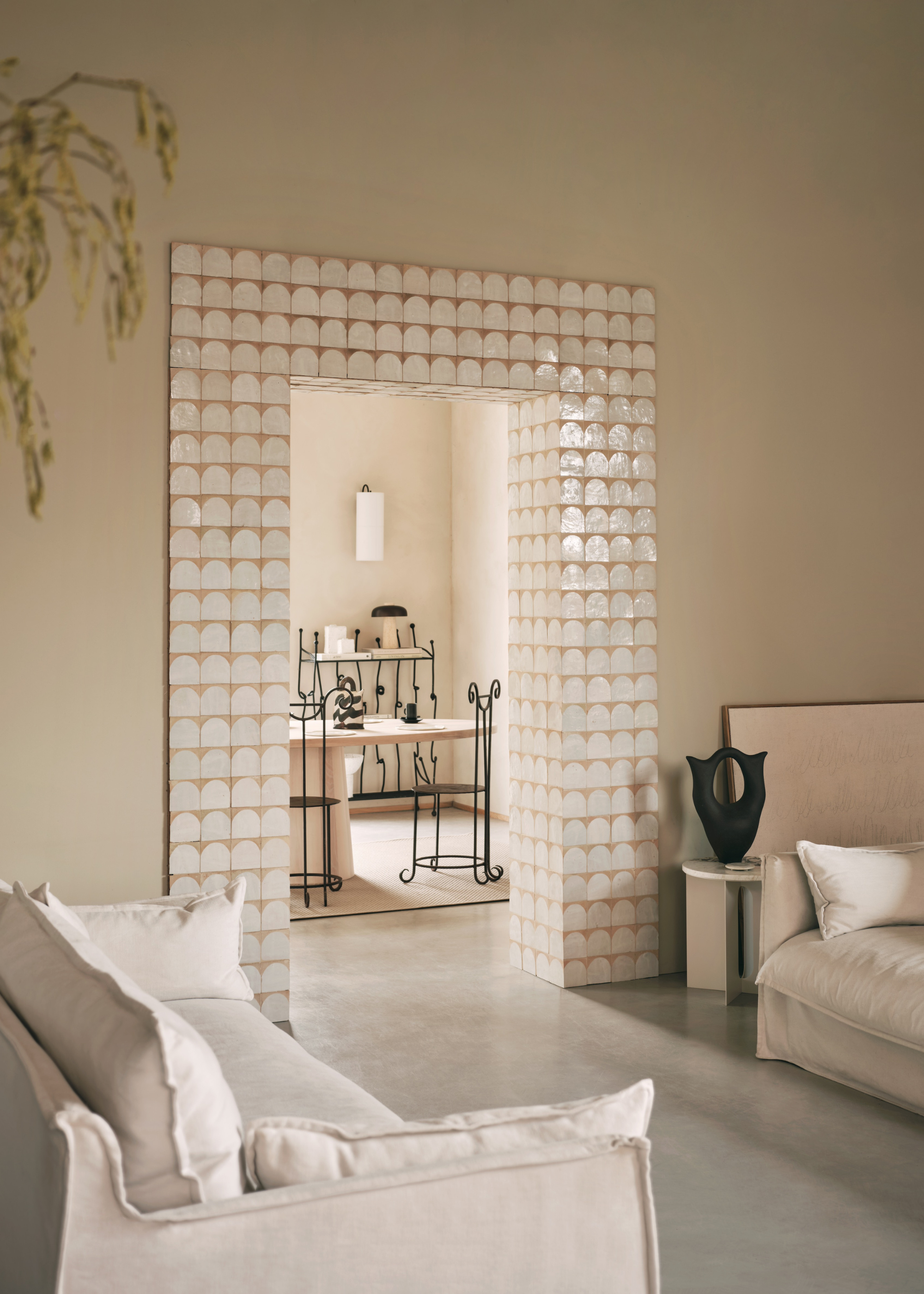 a light neutral room with a tiled doorway in a living area that also has two sofas and a view of the dining area