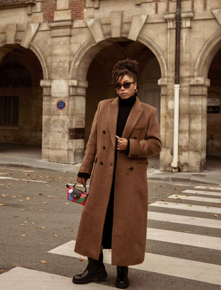 Ellie Delphine wears a wool coat and chunky boots