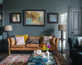 A living room with brown sofa idea with aged leather sofa and teal walls