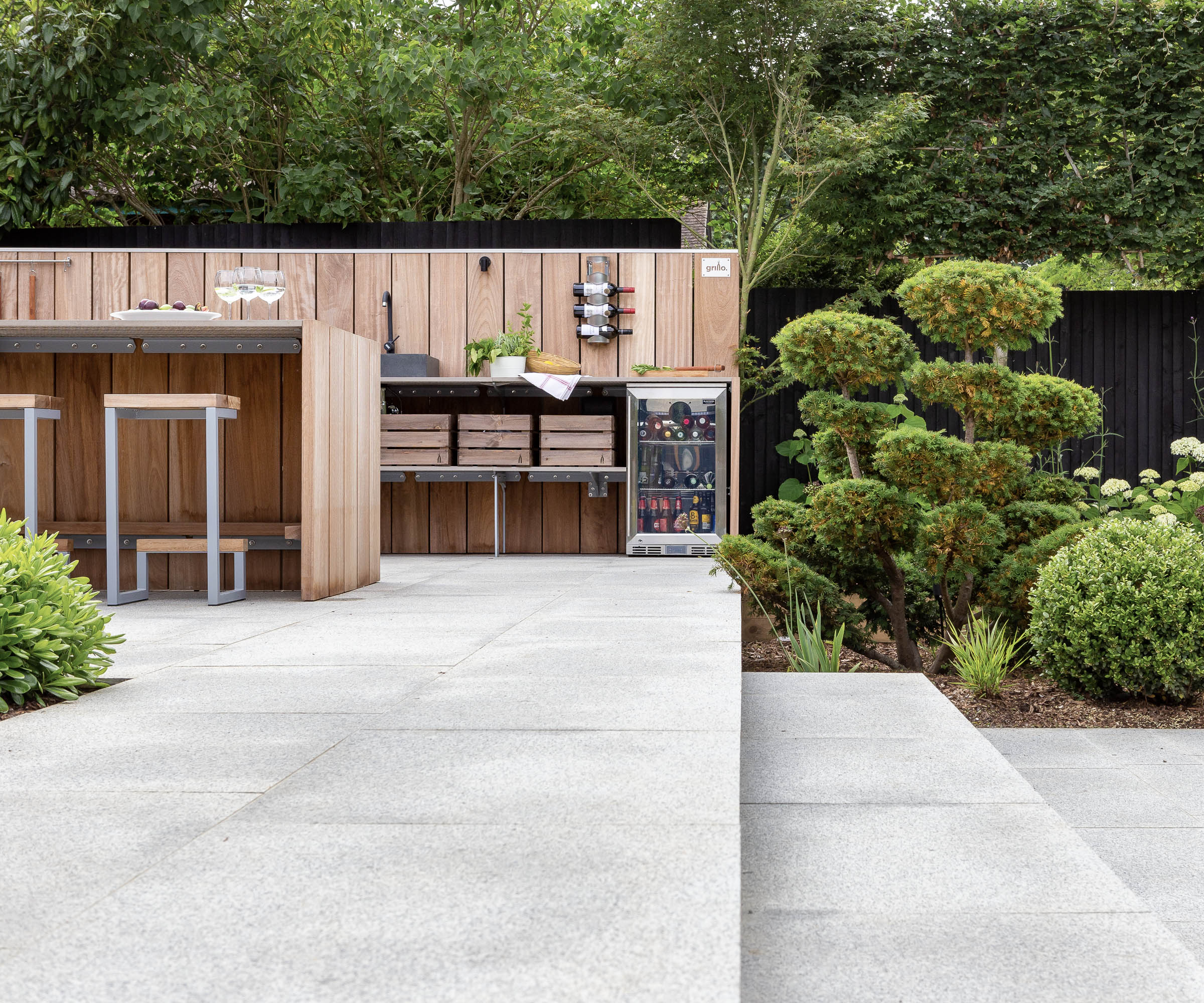 A sleek timber outdoor kitchen with an outdoor fridge