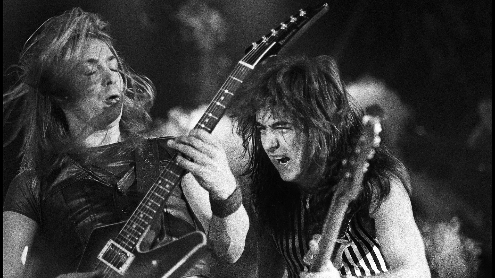 Black and white image of Dave Murray and Steve Harris, performing live on stage at Palais des Sport, Reims, France on May 23, 1982