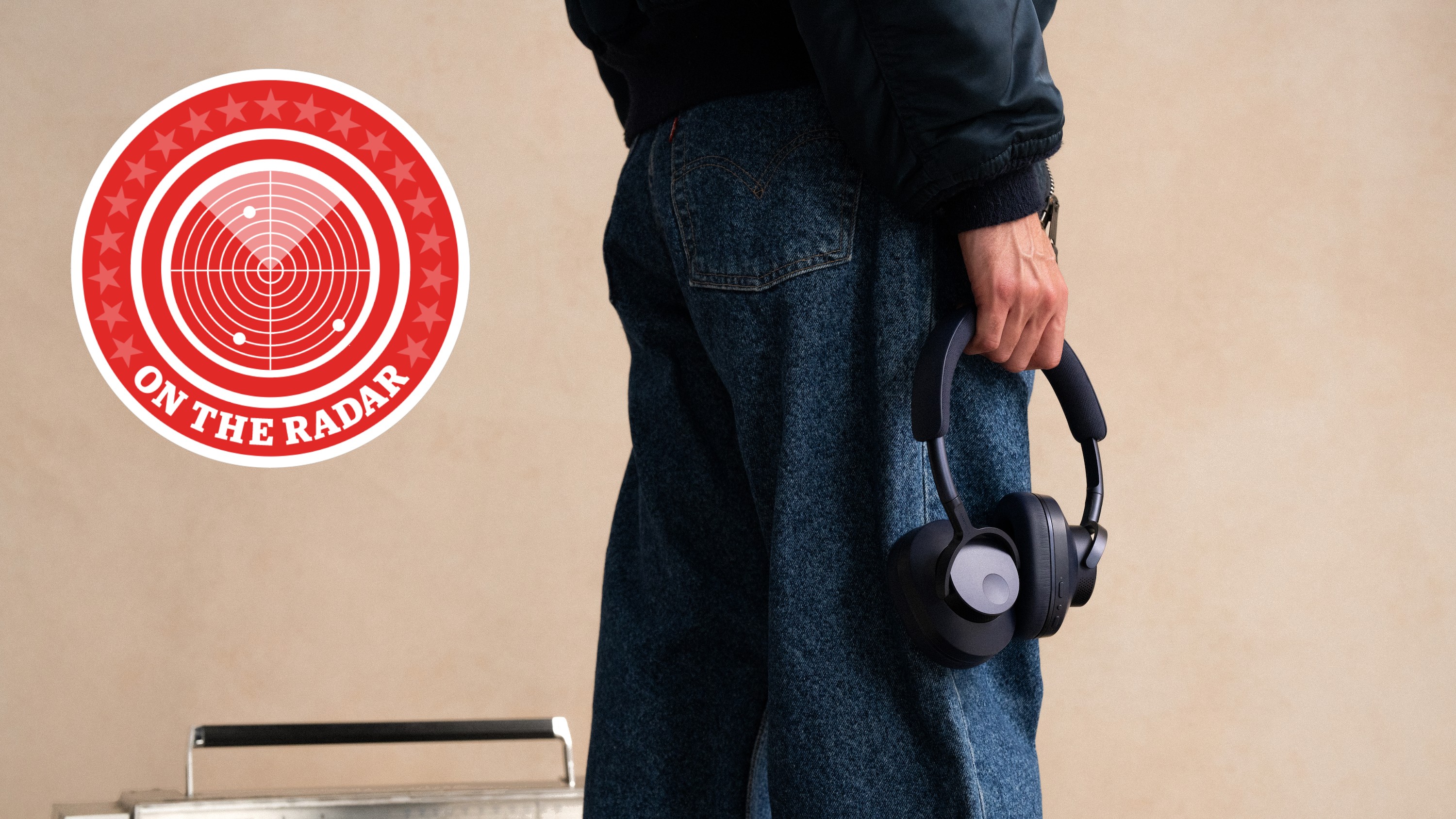 Someone holding a pair of headphones with their back turned to the camera. A radar logo with "On the Radar" is on the left.