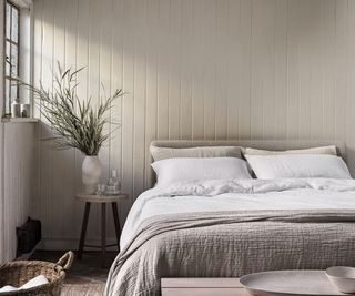Naturalmat Organic Hemp Bedding on a bed against a pale panelled wall.