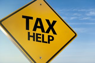 yellow and black street sign that says tax help