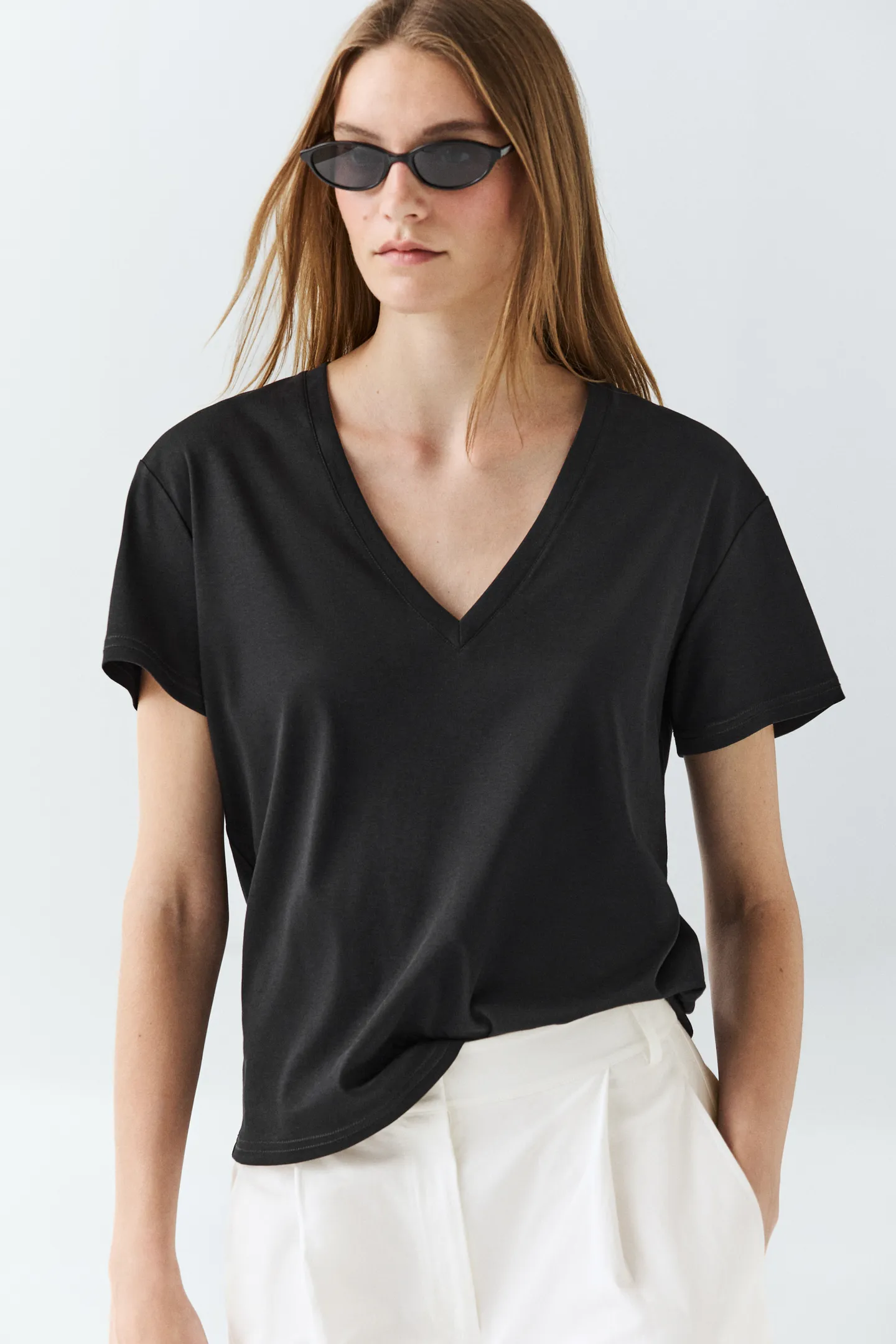 A model wears a black Massimo Dutti v-neck t-shirt.