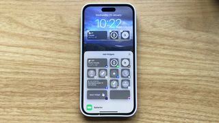 iPhone Pro Max on desk with lock screen customisation options open on screen