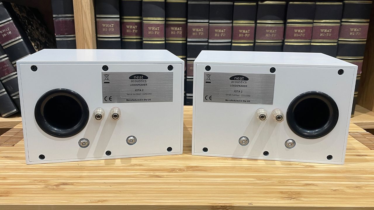 Neat Iota II speakers in white finish placed on wooden shelf