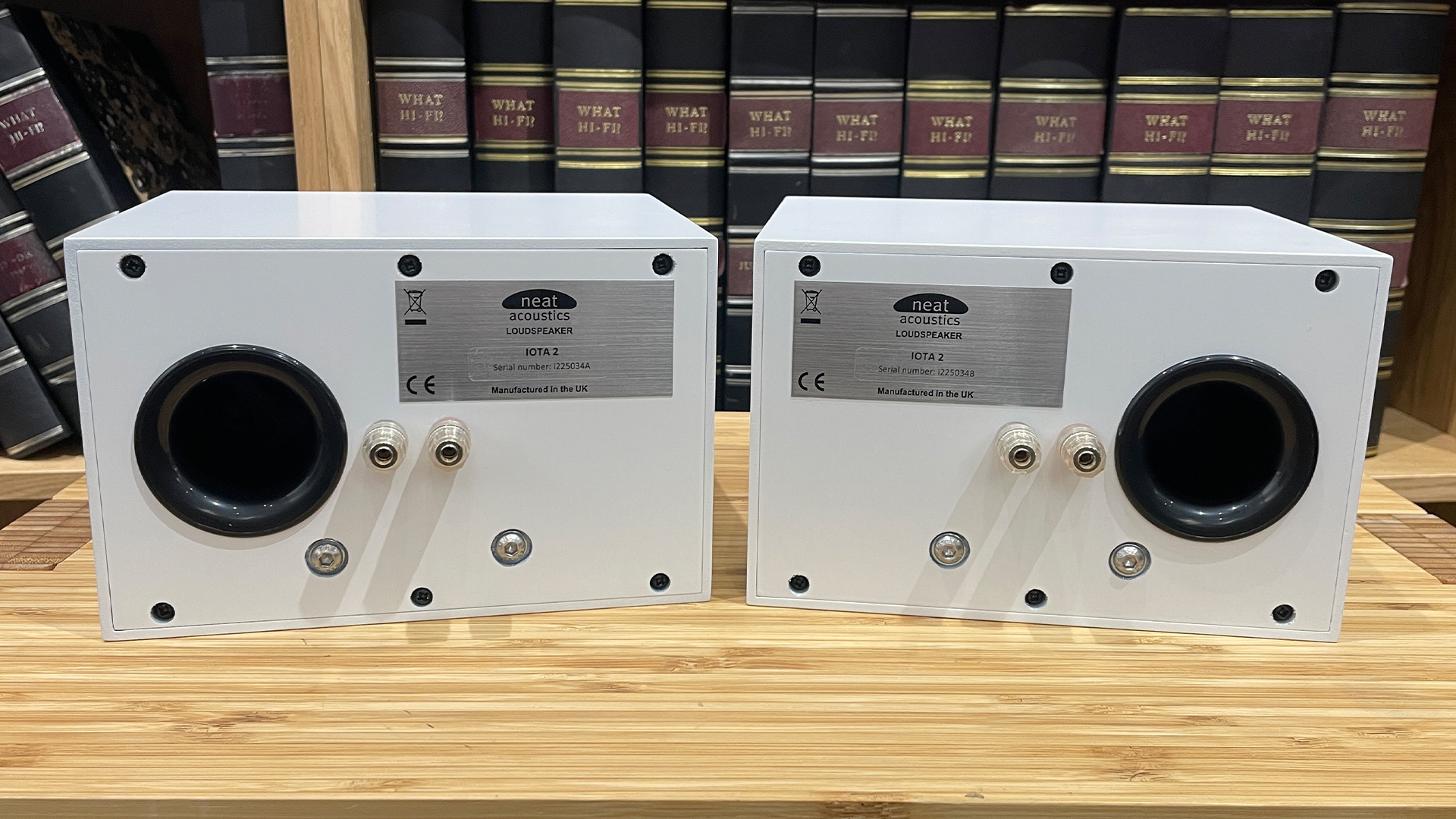 Neat Iota II speakers in white finish placed on wooden shelf