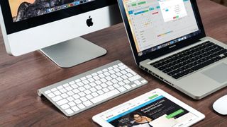 Several Mac computers and laptops on a table