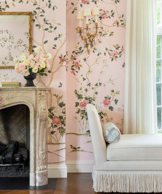 pink floral mural wallpaper in a grandmillennial style living room with a marble fireplace