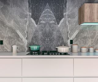 bookmatched grey marble and stone splashback with triangle pattern created behind integrated hob