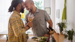 Healthy couple drinking wine and preparing dinner