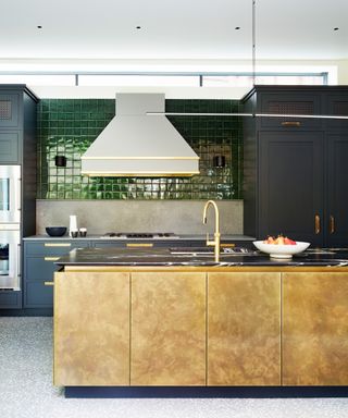 Kitchen with metallic island and backsplash and blue cabinets