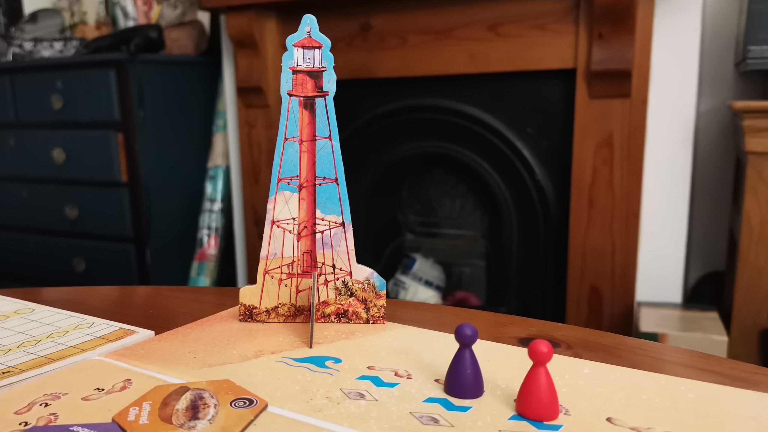 Sanibel board, tokens, and pieces on a wooden surface