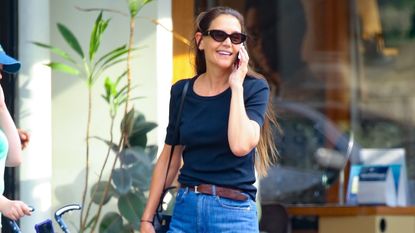 Katie Holmes wearing a navy blue tee with wide-leg denim jeans, black flats, and a brown maxi bag in New York City July 2024