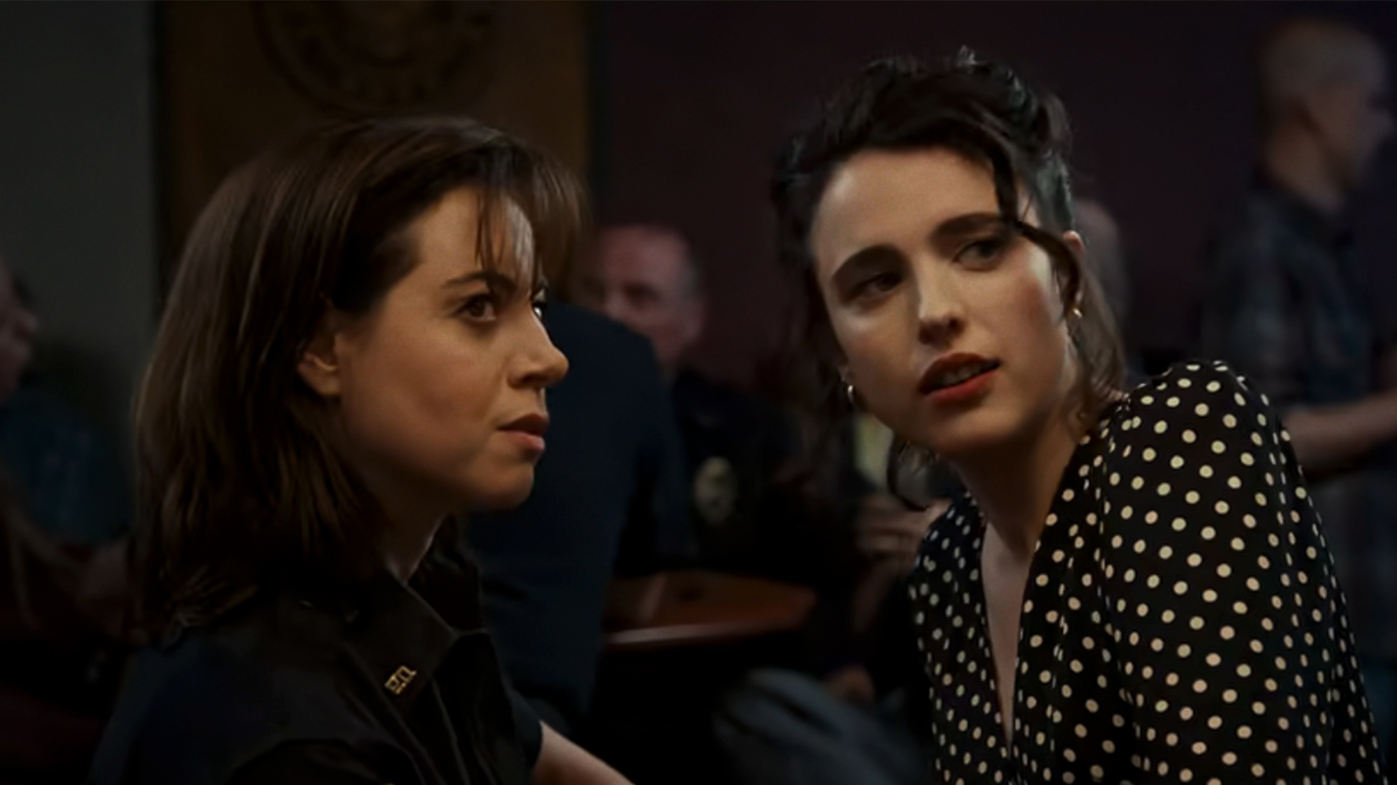 Aubrey Plaza sitting next to Margaret Qualley in Honey Don't