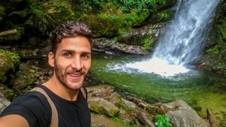 Portrait Of Smiling Young Man In Waterfall