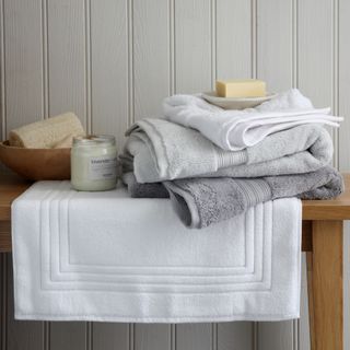 pile of bath towels on a bench