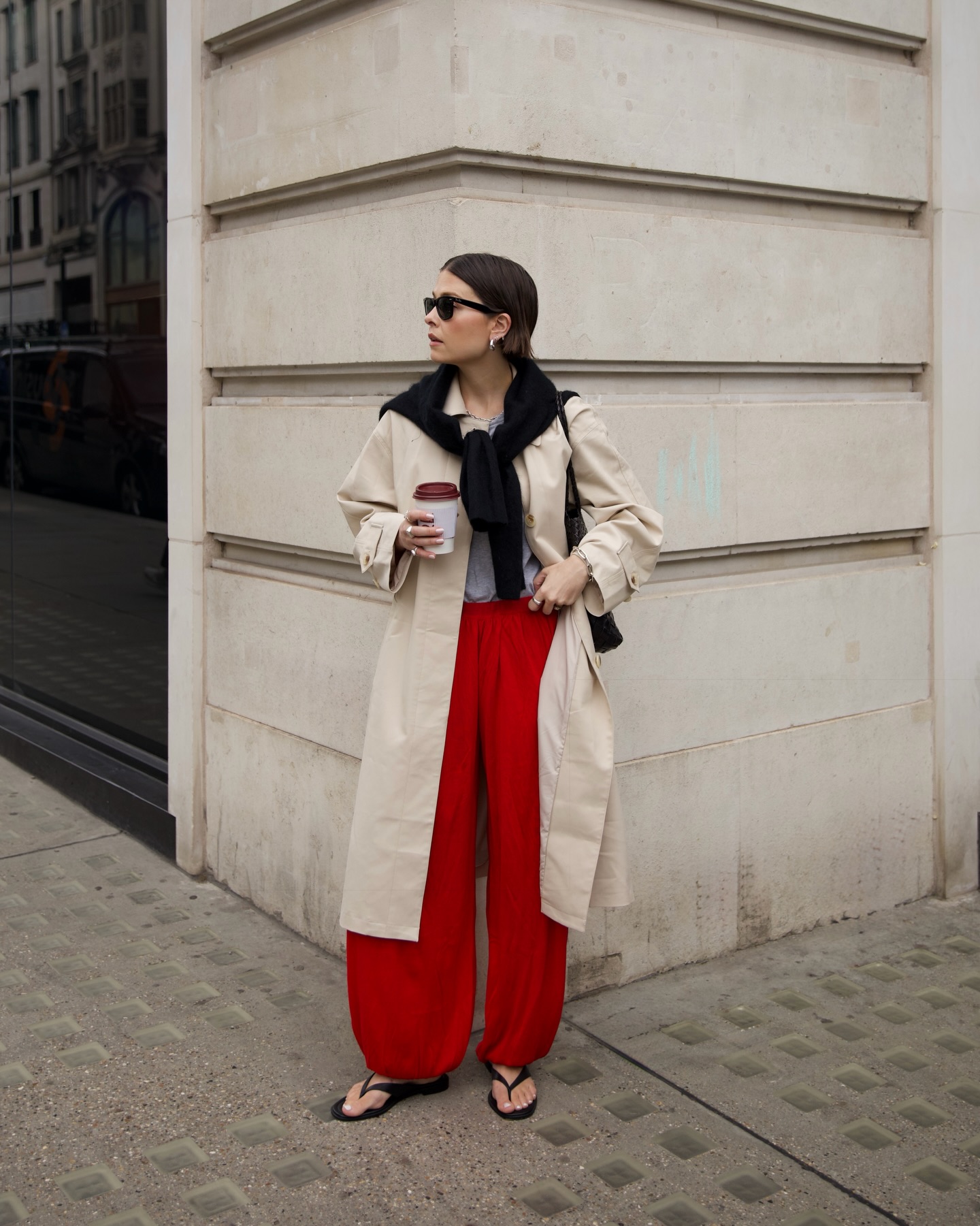 thealiceedit wears a trench coat, red trousers and minimalist flip flops london summer capsule wardrobe