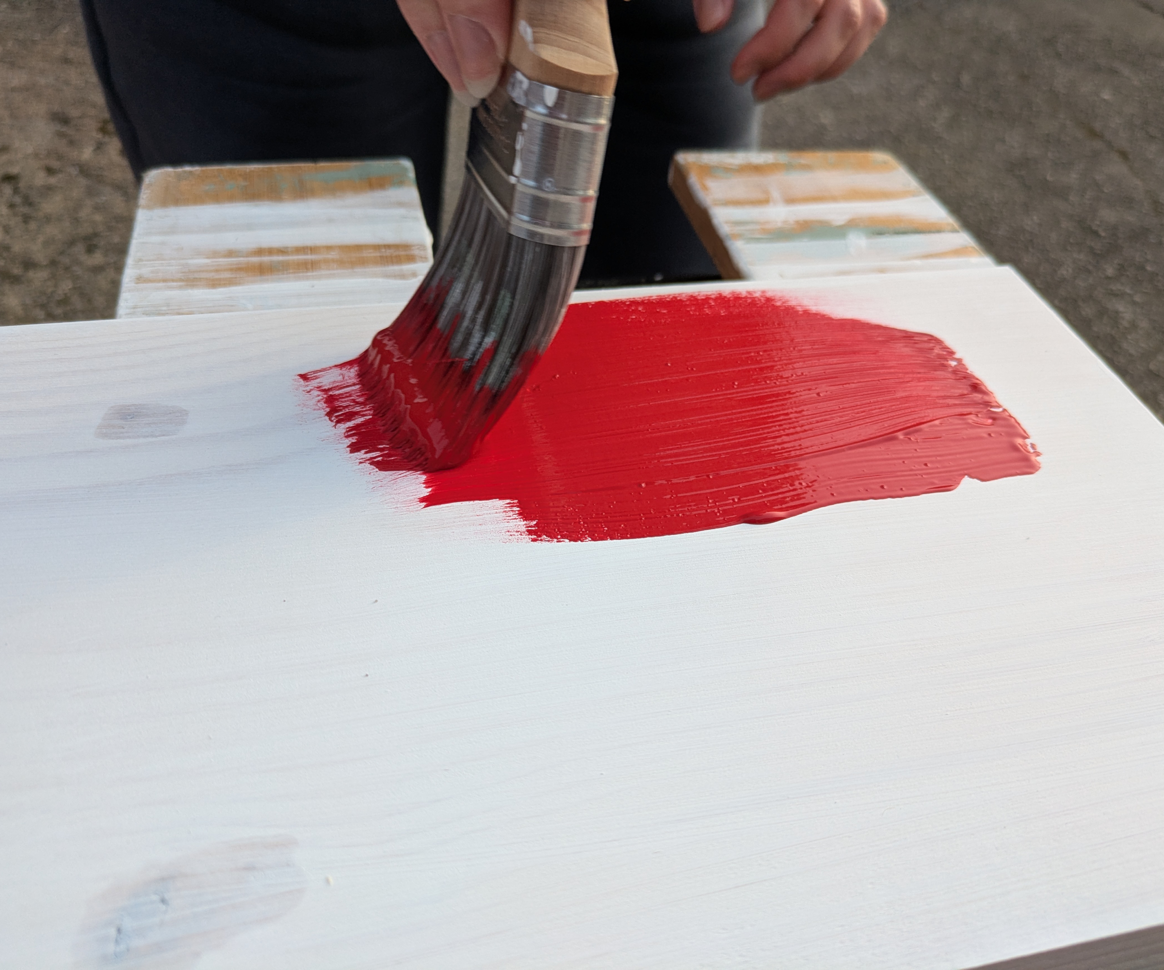 Painting a shelf bright red using a paintbrush