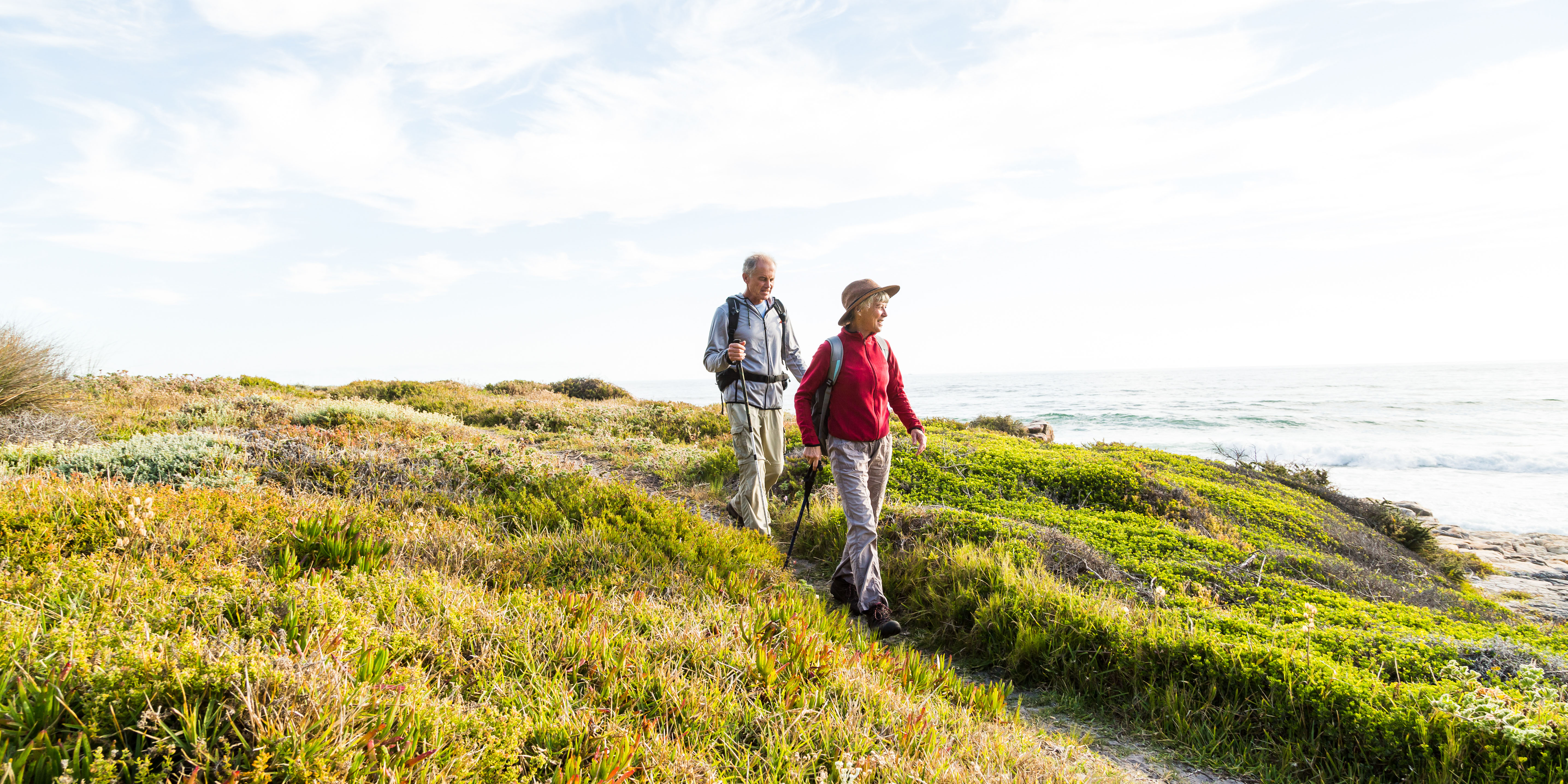 Senior couple hiking on grassy hill