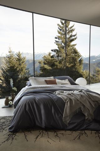 Bed sits in front of a large window