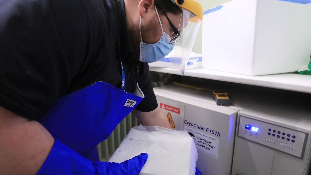 A technician at Croydon Health Services takes delivery of the first batch of Covid-19 vaccinations