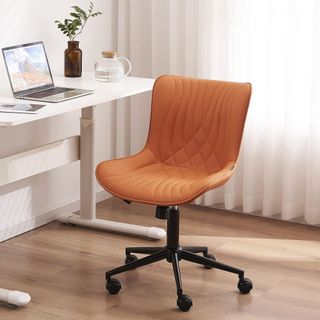 A faux leather office chair sitting on laminate flooring