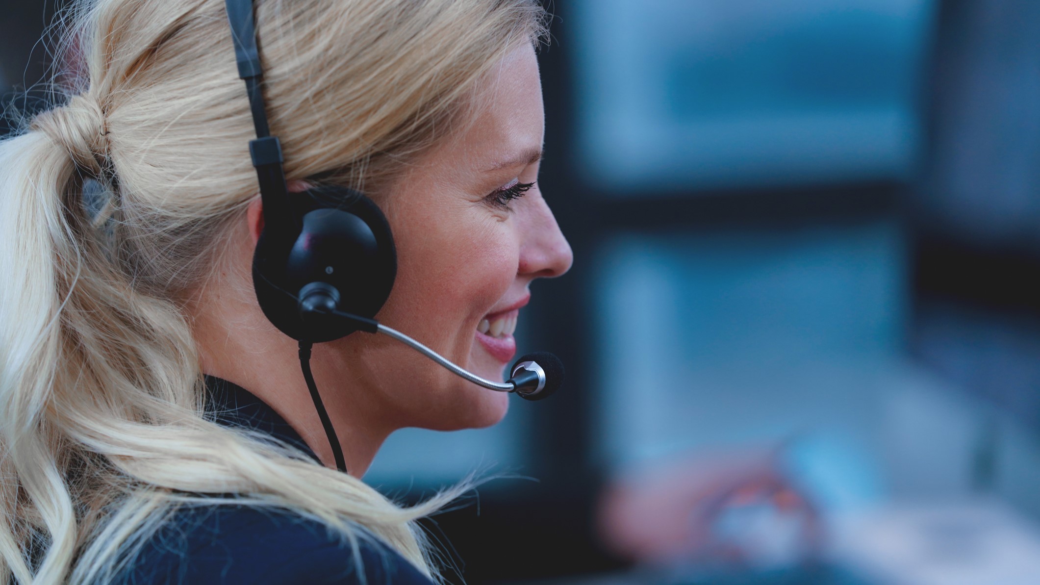 Aloha POS system customer service: Blond woman smiles with headset on