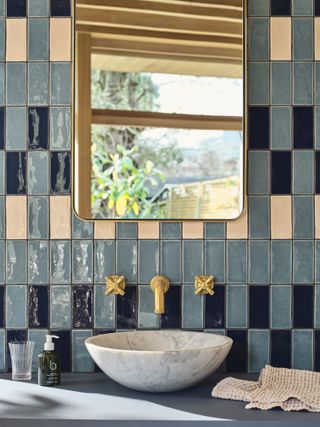 Bathroom splashback with dark and light blue and cream tiles