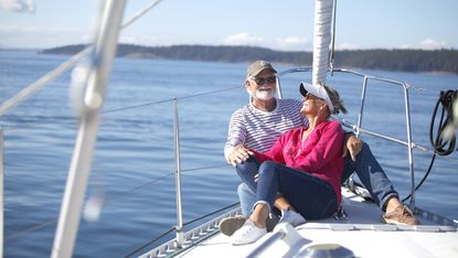 Senior couple relaxing, laughing and exploring on sailboat in the Salish Sea