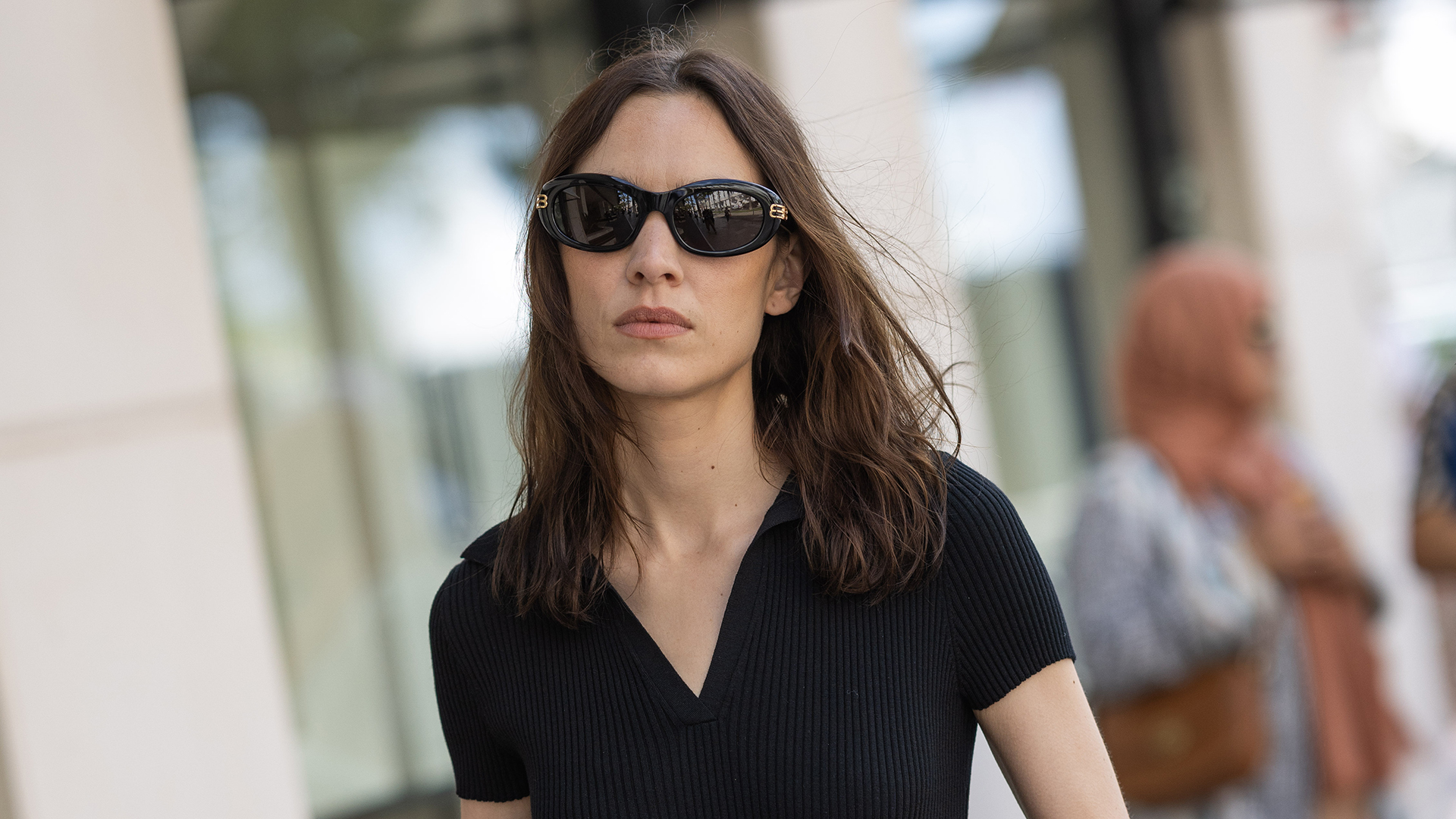 Alexa Chung wearing a black mini dress and sunglasses