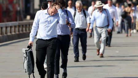Commuters walk in the sun as they cross London Bridge , during a heatwave, in central London on June 24, 2026. The UK recorded its hottest ever June temperature