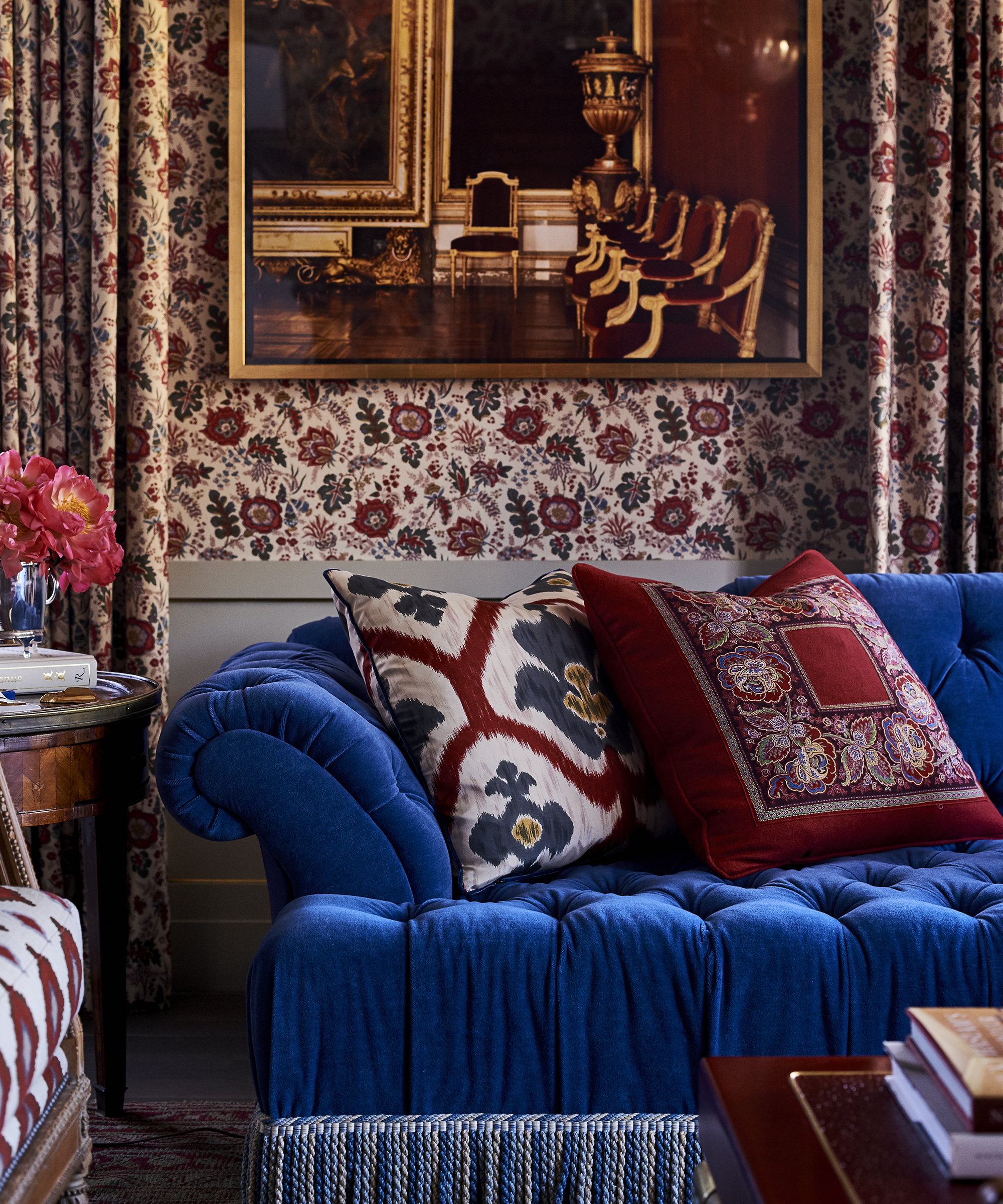 decorative living room with patterned floral wallpaper and bright blue sofa