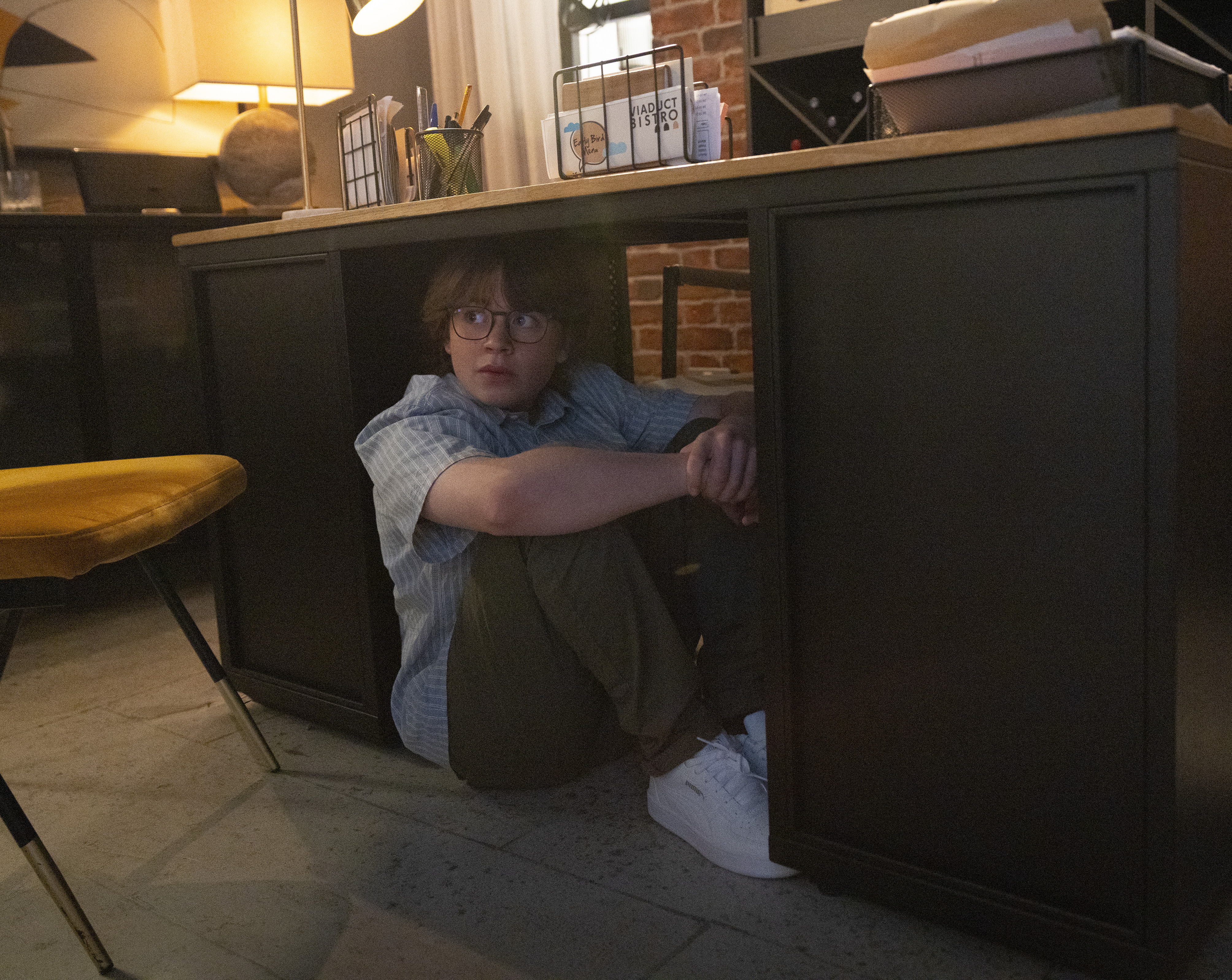 Sam Blakeman hides under the desk in the Bistro office
