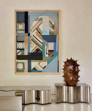 wave-edged steel coffee tables with modern artwork behind